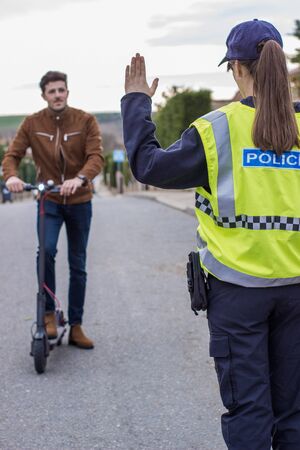 policeman stops a boy on electric scooter to file complaintの写真素材