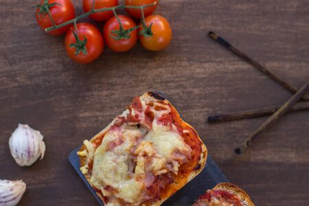 Plate of handmade panini with natural tomato on slate plate in overhead scene