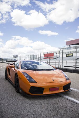Orange Lamborghini luxury car on a race track prepared to run on a sunny summer dayのeditorial素材