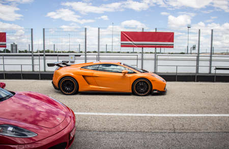 Orange Lamborghini luxury car on a race track prepared to run on a sunny summer dayのeditorial素材