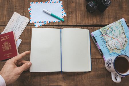 open notebook on a wooden table to plan a trip and write down ideasの写真素材