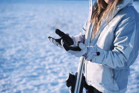 close up of girl's hands hesitating in the snow. equipped with gloves.の写真素材