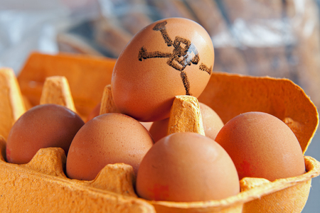 Tray of brown eggs, one marked with a skull & Crossbonesの写真素材