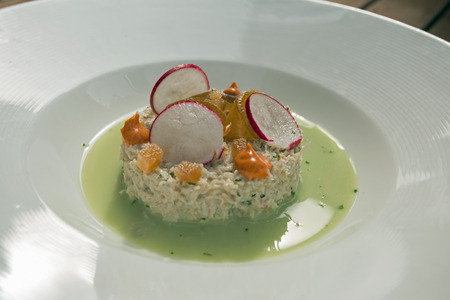 Delicious crab salad in watercress sauce topped with pears, radish and paprikaの写真素材