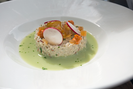 Delicious crab salad in watercress sauce topped with pears, radish and paprikaの写真素材