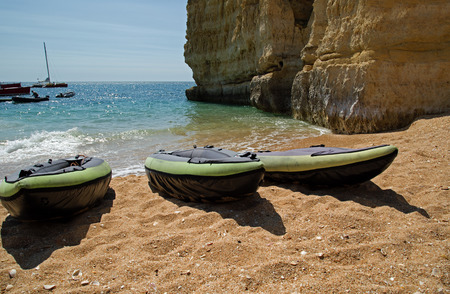 Three canoes on a sandy beach in The Algarve on a sunny day.の写真素材