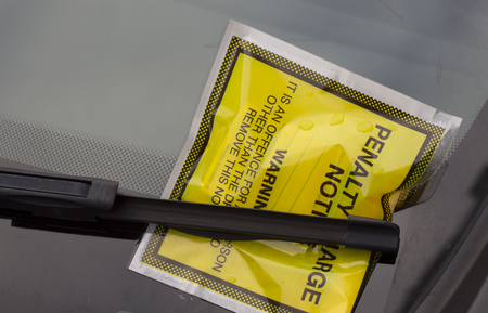 A yellow penalty notice fixed on a car windscreenの写真素材