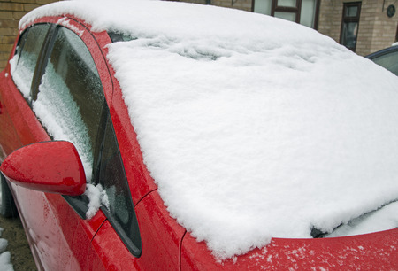 Snow on the windscreen of a red carの写真素材