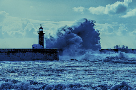 Porto lighthouse in blue with huge waves and puffy cloudsの写真素材