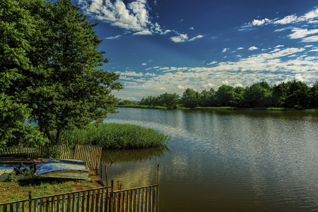 Cloudy lakescape with fishing boatsの写真素材