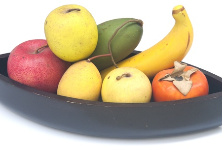 Fruit placed in a black dish. A group of fruit are apples, mango, orange, banana with white isolated.の写真素材