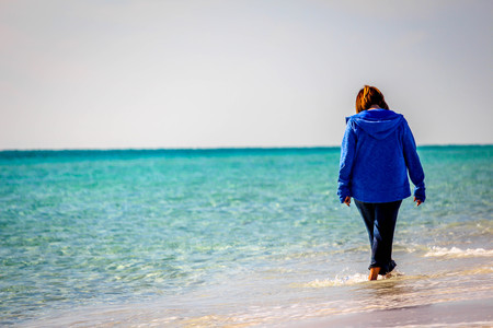 Beautiful beach scene of the Emerald Coast of Florida with people and/or dog, Waves slowly washing ashore. Sky is deep blue, water a beautiful teal, and the sand is a sugary white all in the Florida panhandle.の写真素材