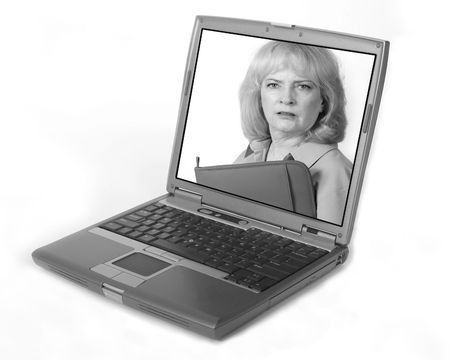 Older business woman looks at your from the screen of the laptopの写真素材