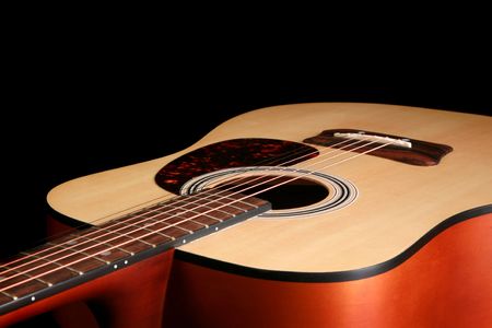 Close up of a guitar isolated on a black background