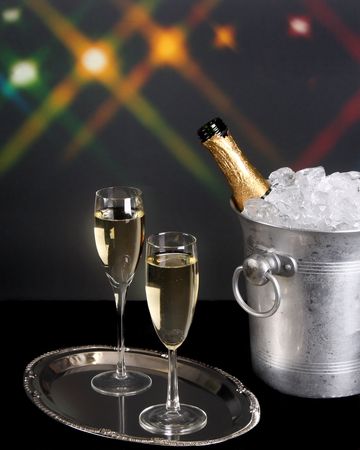 Champagne on a silver tray with background lightsの写真素材