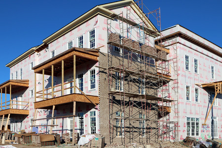 FRANKLIN, TN-SEPTEMBER, 2015:  Upscale condos under construction in a planned community.  The scaffolding for the brick layers is prominent in the image.のeditorial素材