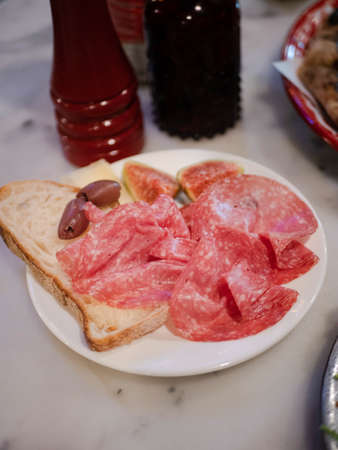 a plate with salami sausage with bread in italian restaurantの写真素材