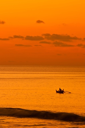 sunset over the sea and fishermanの写真素材