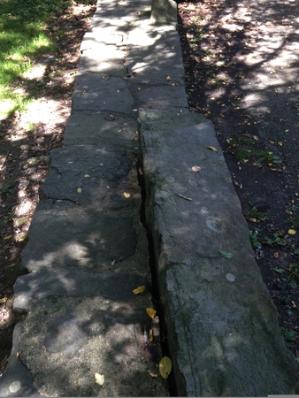 Top view of a stone wall with dirt and grass in daylightの写真素材
