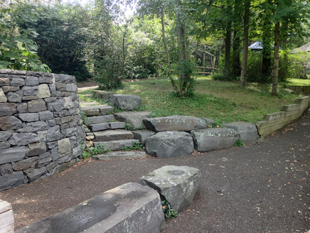 Stonewall and steps around trees in a park settingの写真素材
