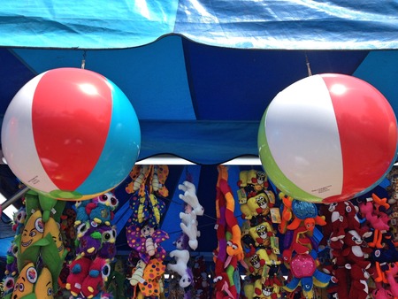 Beach ball prize at a carnival game hang with other stuffed animalsの写真素材