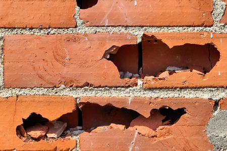 Red brick wall with broken blocks.の写真素材