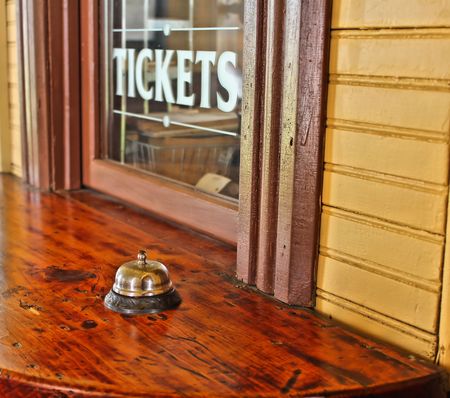 Ticket window with service bell on wooden counter.の写真素材