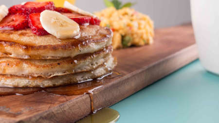 Breakfast with pancakes, bananas and maple syrup with eggsの写真素材
