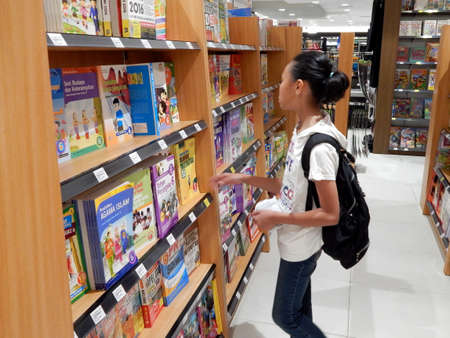 A girl is focus reading a book in a book store of Gramedia. Manado 19th March 2016