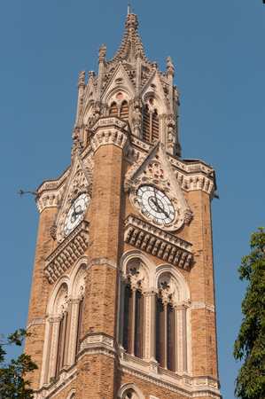 Rajabai clock tower in Mumbai University fort campus showing intricate carving in stone, with blue...