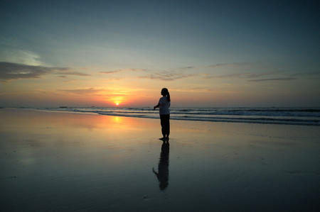 A woman stands at the sunset alone.の写真素材