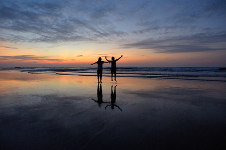 happy kids playing on beach at the sunrise timeの写真素材