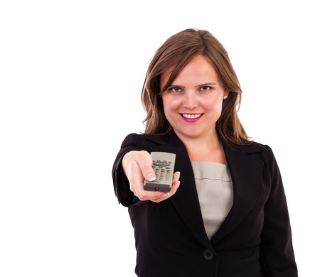 Young business woman using tv remote control isolated on white backgroundの写真素材