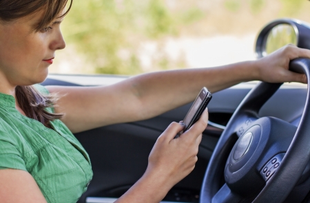 Woman driver reading a text message on a mobileの写真素材