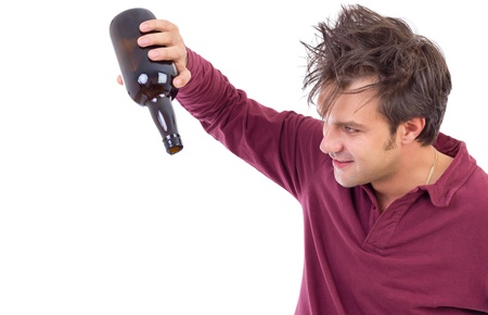 Portrait  of a drunk man  looking  at an empty alcohol botlle isolated on whiteの写真素材
