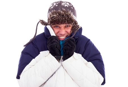 Young man with hat and coat  shivering  from cold over white backgroundの写真素材