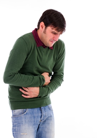 Young man with strong stomach pain isolated on white backgroundの写真素材