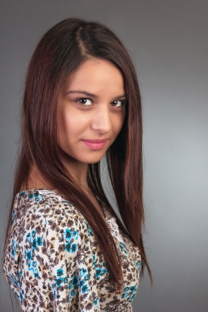Close up portrait of beautiful young woman with  long hair over grey backgroundの写真素材