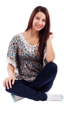 Smiling pretty woman wearing jeans sitting on  floor isolated on whiteの写真素材