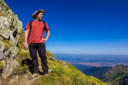 Tourist looking at view during a hiking trip in mountainsの写真素材