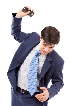 Angry businessman throwing  his mobile phone isolated on white backgroundの写真素材