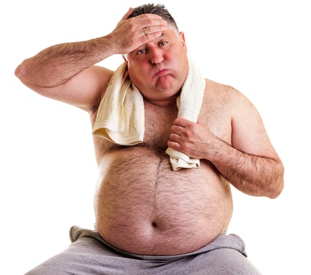 Overweight man resting, tired after training, with hand on forehead against whiteの写真素材