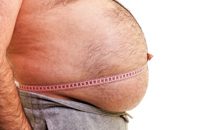 Closeup of a big belly surrounded by a measuring tape over white background