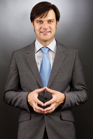 Portrait of a hansome young businessman against gray backgroundの写真素材