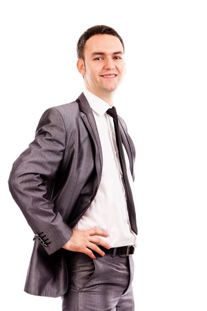 Smiling young business man with hands on hips against white backgroundの写真素材