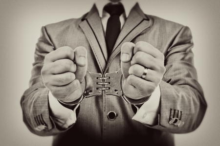 Monochrome portrait of a businessman's hands with handcuffsの写真素材