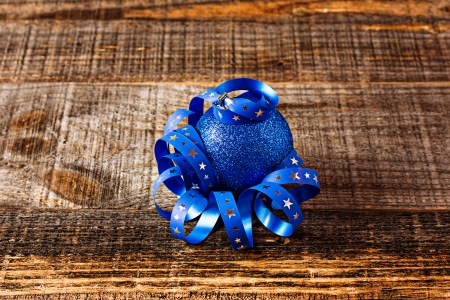 Closeup of blue  christmas ball with ribbon isolated on wooden の写真素材