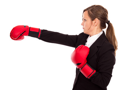 Businesswoman with boxing gloves punching and hitting standing in  profile,business competition concept,isolated over white backdroundの写真素材