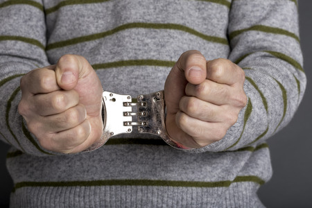 Conceptual image of an arrested man with handcuffsの写真素材