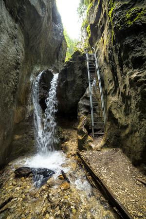 Fresh water stream flowing down through mountain rocksの写真素材